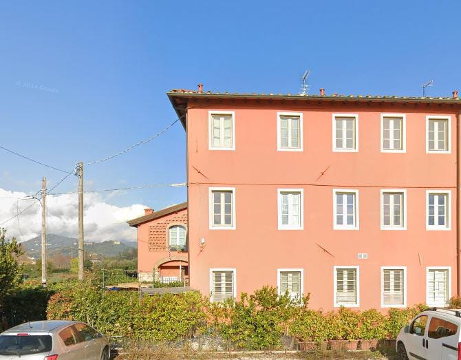 Il fronte principale di Condominio Castelli, a tre piani con le finestre allineate e il portico d’ingresso.