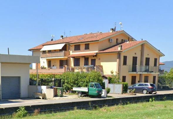 Il complesso di Condominio Tau con i tetti a falde, le logge in legno e il parcheggio scoperto.