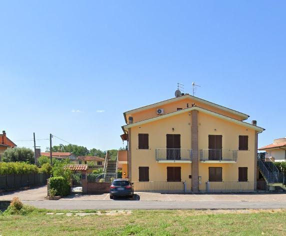 Condominio Tau: la palazzina gialla a due piani con le logge e la scala esterna sul fianco.