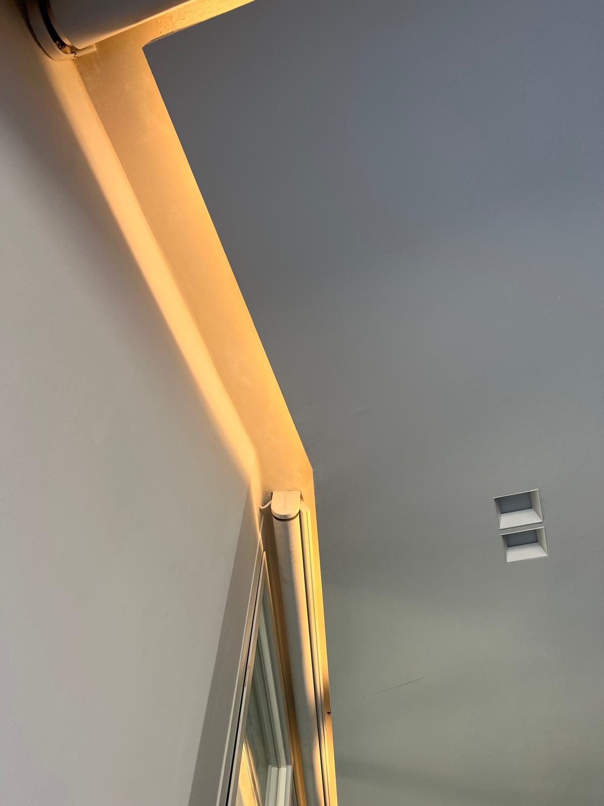 Dettaglio di FRAME: la luce radente che scende lungo lo spigolo della loggia al tramonto.