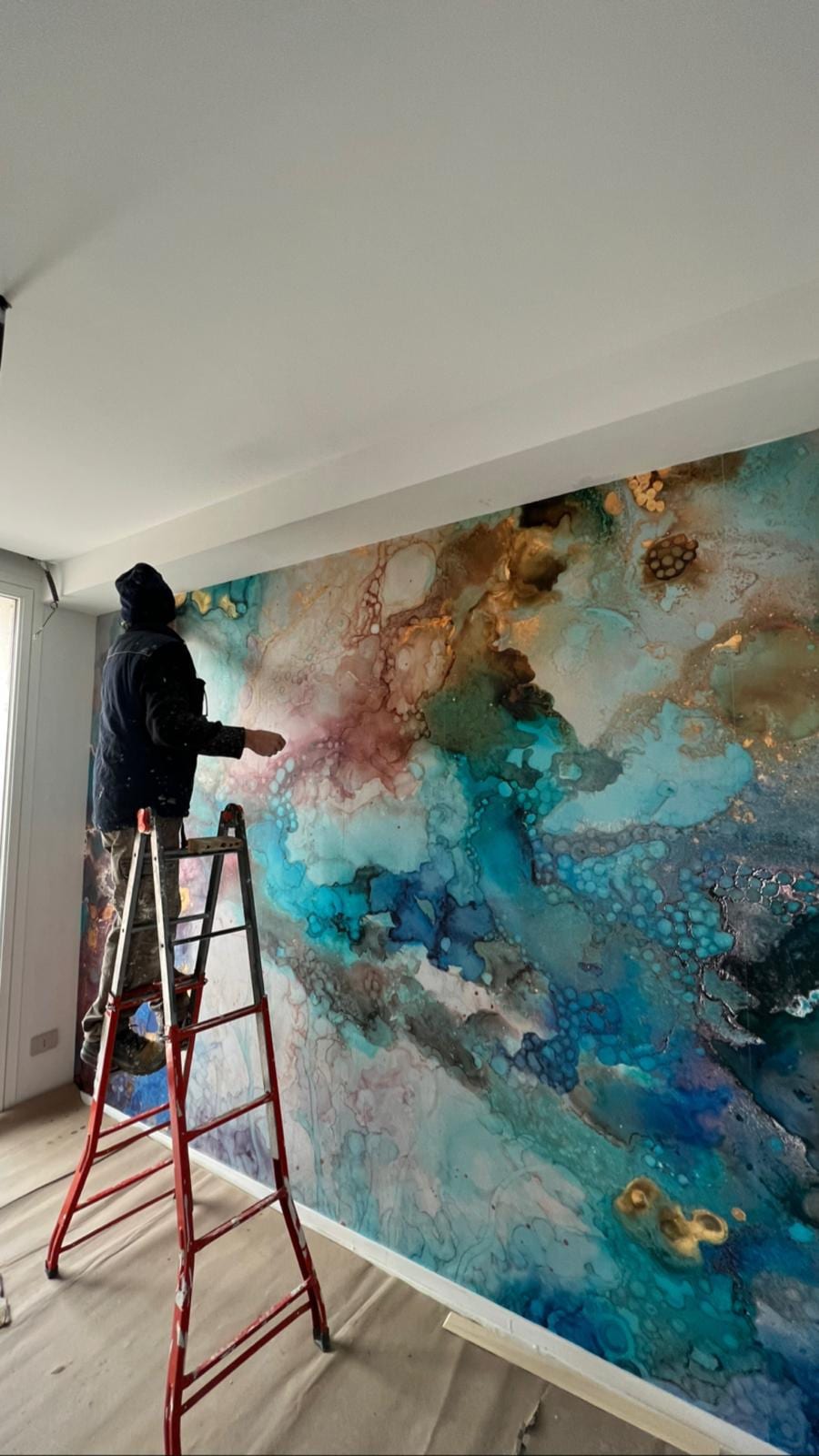 L’atrio di FRAME durante la realizzazione del murale che riveste per intero la parete di fondo.