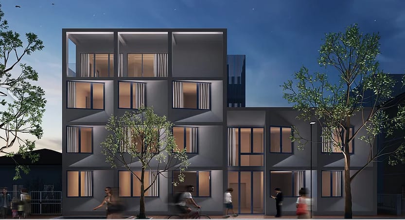 Rendering notturno di FRAME: i due volumi affacciati sulla strada, con le logge illuminate.