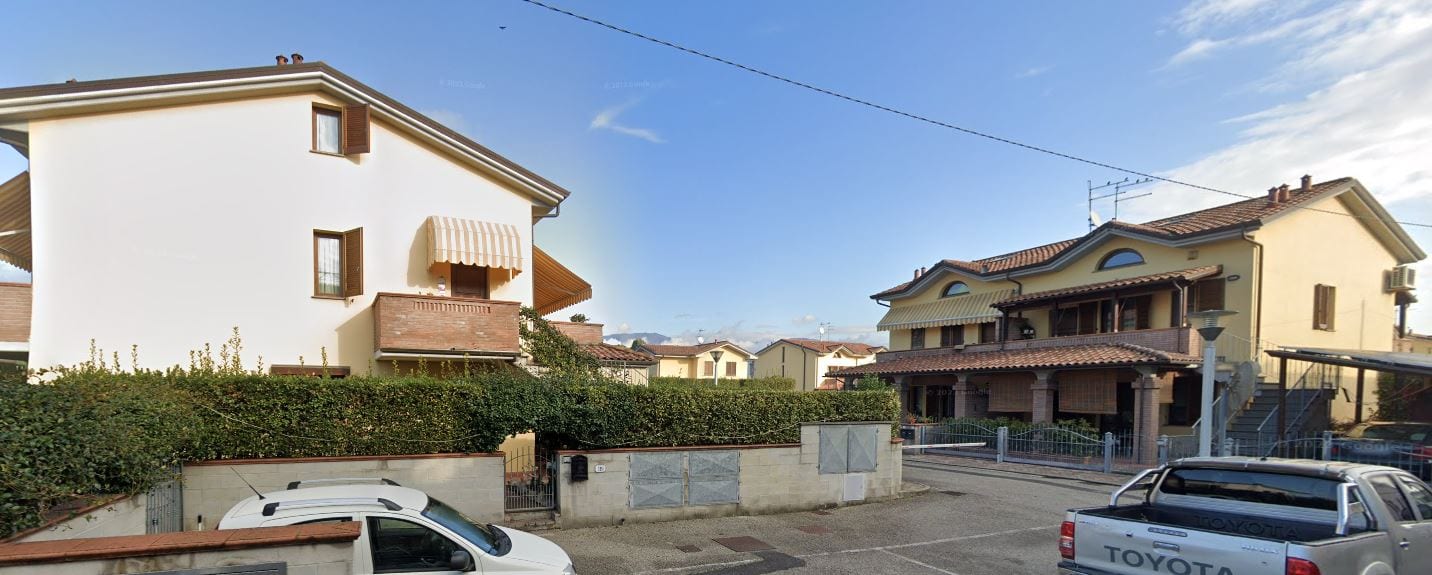 Due corpi di fabbrica di Le Fresie visti dal parcheggio, con le tende da sole sulle logge.