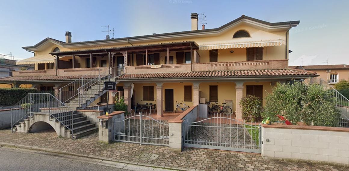 Un edificio di Le Fresie con doppio ordine di logge, scala esterna e portico al piano terra.