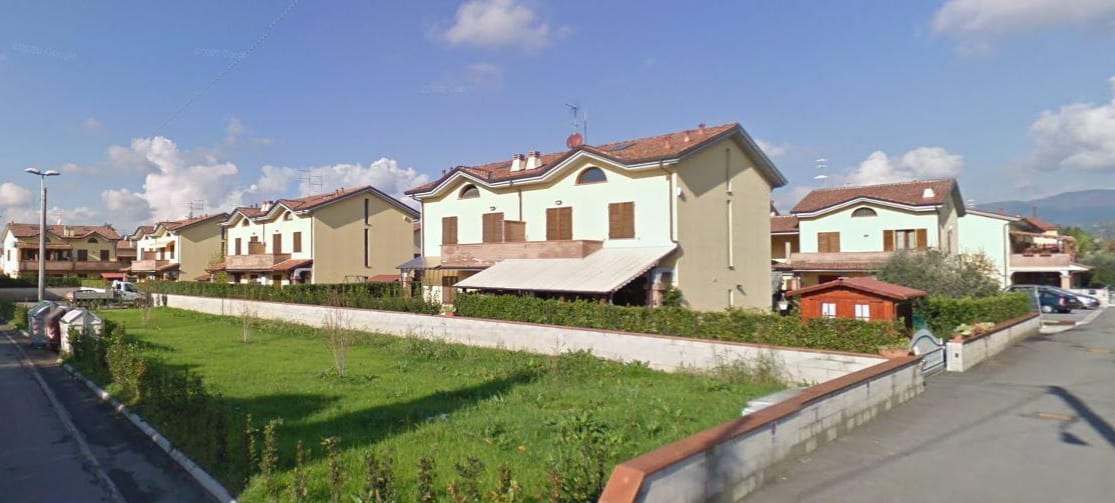 Le Fresie: la fila di villette a schiera vista dal prato, con i tetti a due falde e le logge al primo piano.