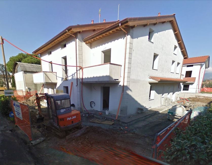 Il cantiere di Residence Ulivo con l’escavatore al lavoro davanti al fabbricato al grezzo.