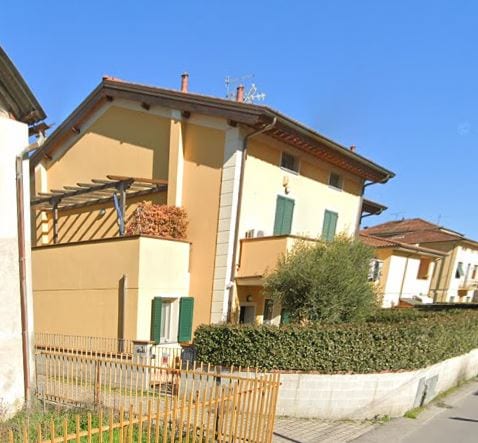 Un corpo di Residence Ulivo con il pergolato al primo piano e la scala esterna in muratura.