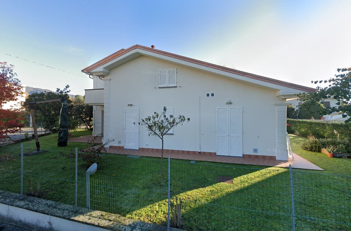 Il fronte laterale di Villa Vittoria con le persiane chiare e il prato che circonda la casa.