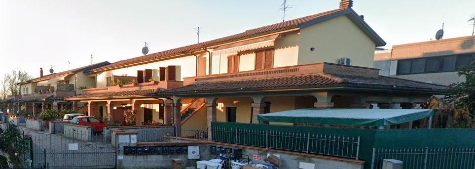 Villaggio Porcari: la fila di unità a schiera con i portici in laterizio e le logge al primo piano.